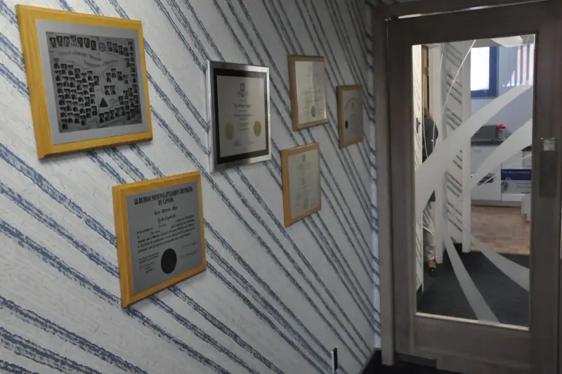 Diplômes et photo de promotion exposés dans l’entrée du cabinet